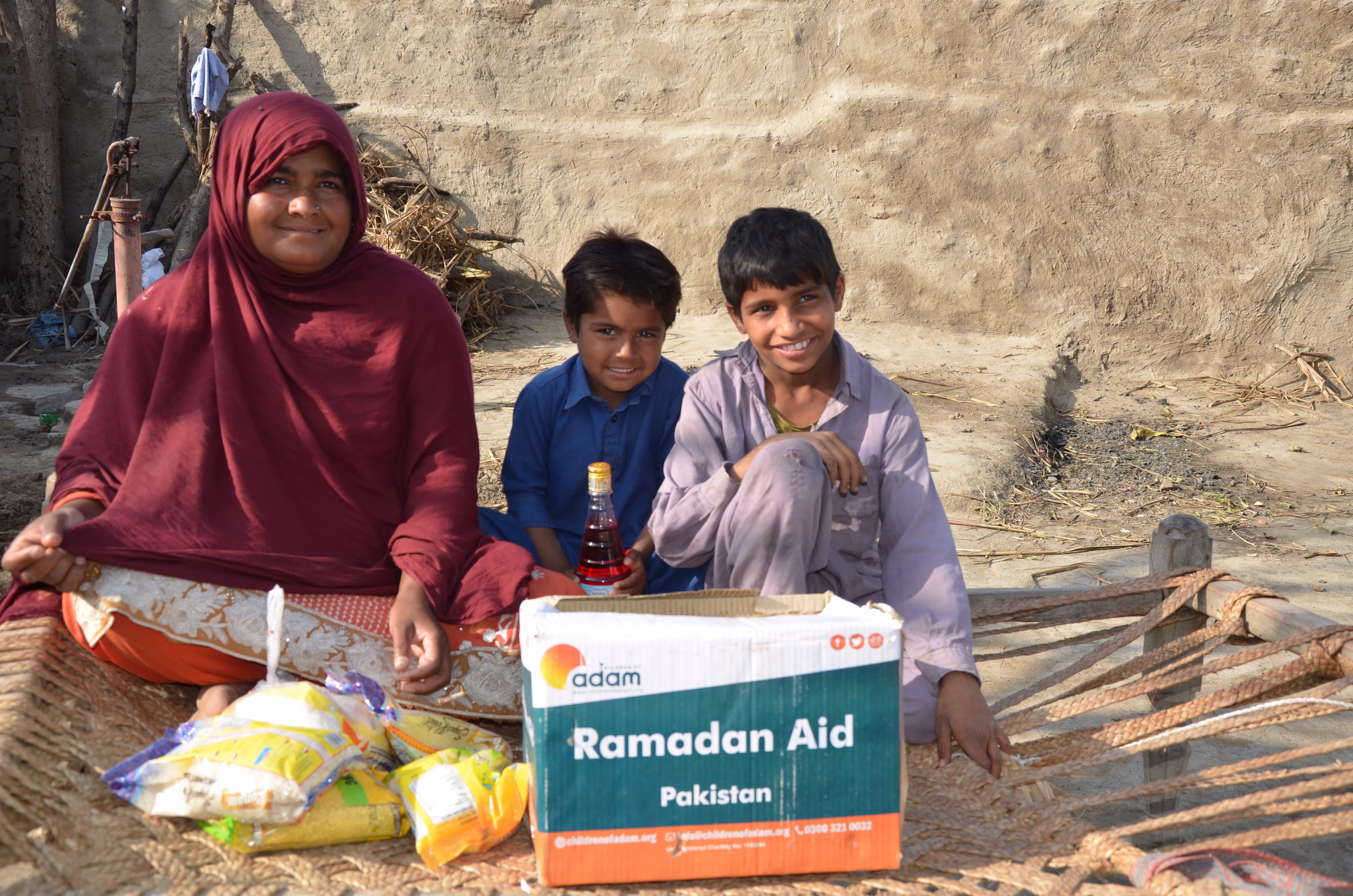 From Your Hands to Theirs: The Journey of Your Ramadan Food Pack 1 mother and child receive ramadan food parcels and smile with happiness